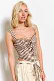 Woman wearing a checkered top and beige skirt against a white background
